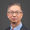Cong-Qiu Chu, M.D., Ph.D. (OHSU) Cong-Qiu has short dark gray hair, eye glasses and is wearing a suit, smiling in a photo studio.