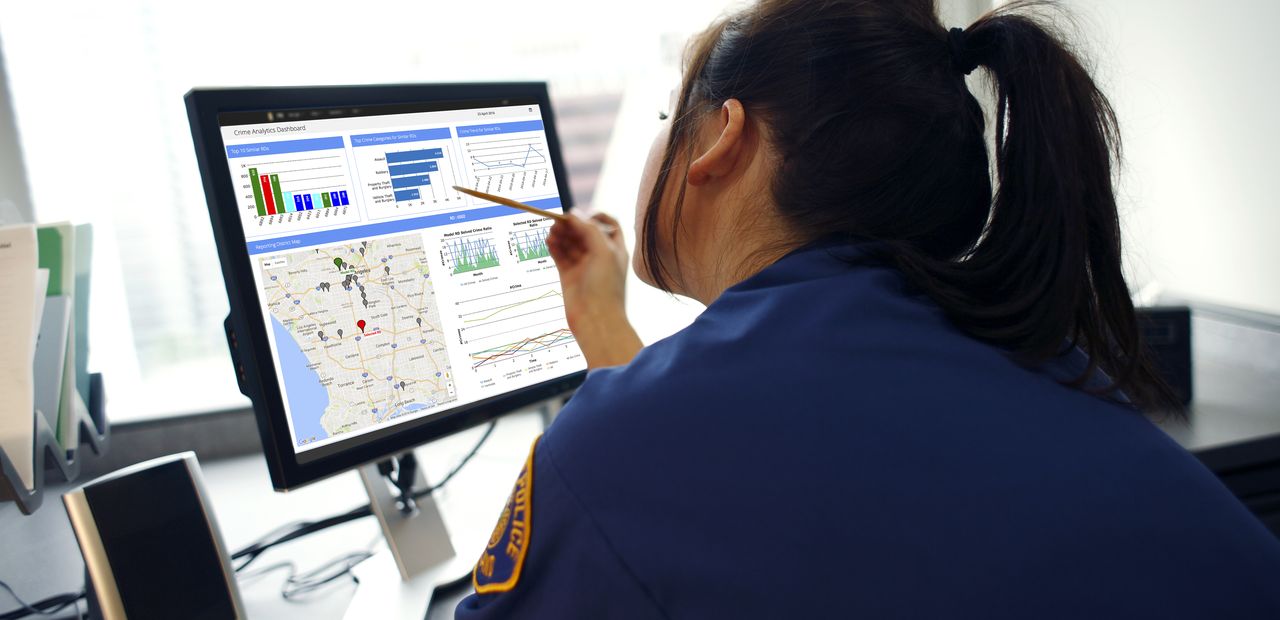 Police officer looking at crime forecasting data available through the Conduent Business Intelligence platform