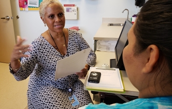 Milagros Amaro works with a patient at the health department 2