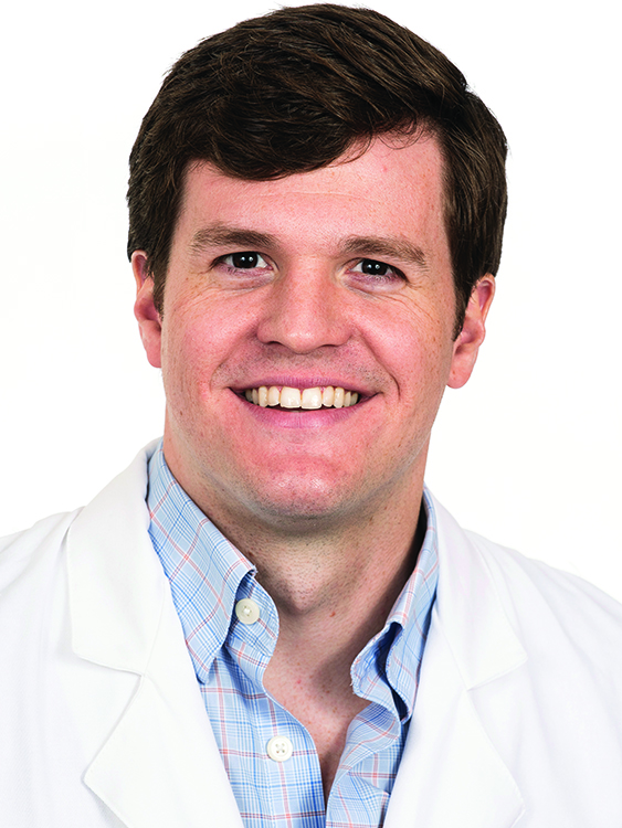 Dr. Chase Bennett smiles in a white lab coat. 