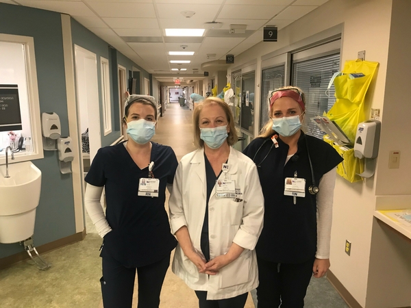 ​ Aiyana Coward, Cindy Little and Cassie Brault, 3rd floor ICU, Presbyterian Medical Center. Top photo: Coward dons the required personal protective equipment team members wear when treating COVID-19 patients.