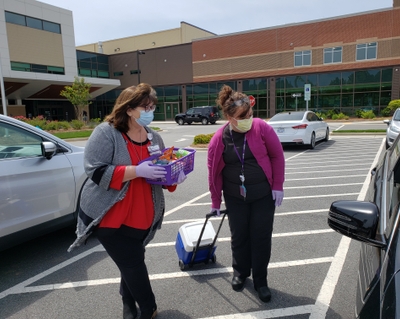 Jamie Vogler and Jo Burleson provide snacks to family members in the parking lot at Novant Health Clemmons Medical Center