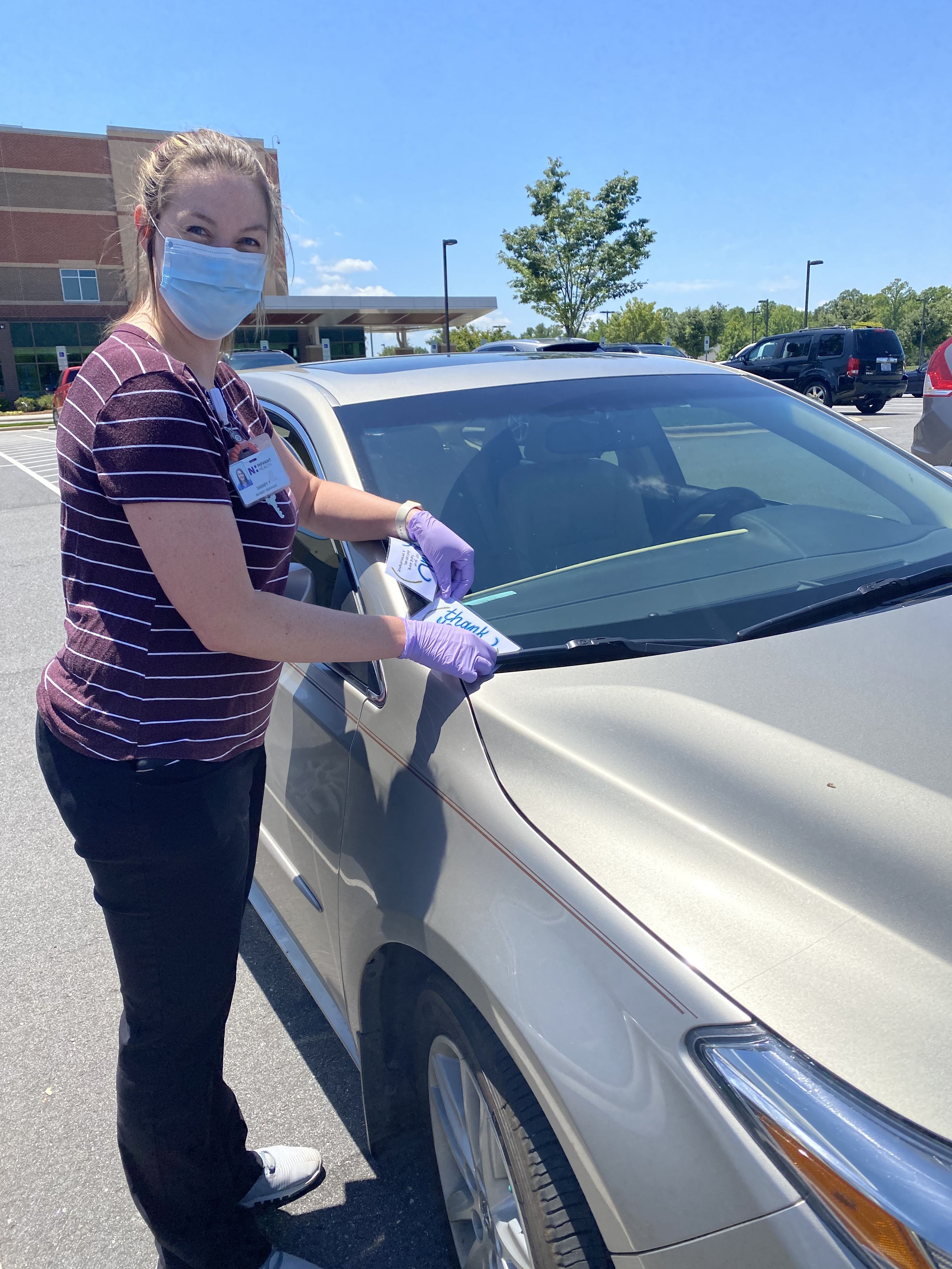 Sidney Yates places a card of encouragement on a car at Novant Health Clemmons Medical Center