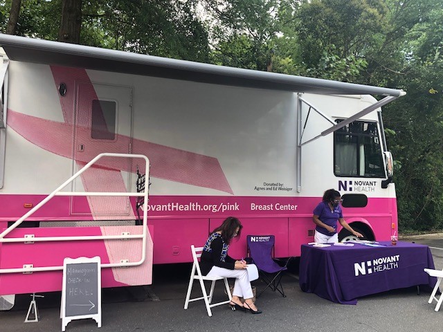 Breast health educator Willie Adams helps a patient prepare for their mammogram.