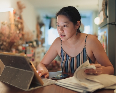 Asian woman looks at computer