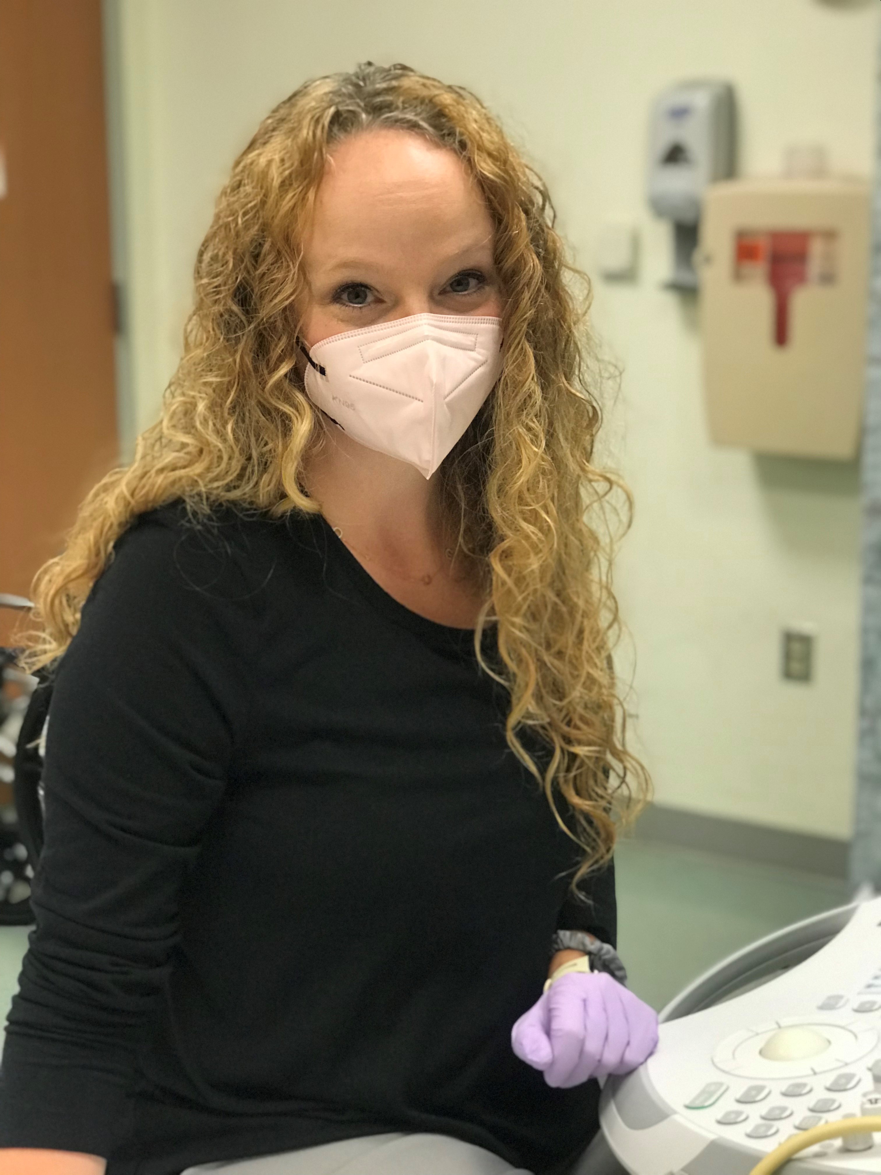 Dr. Amelia Sutton smiles for a photo with a mask on.