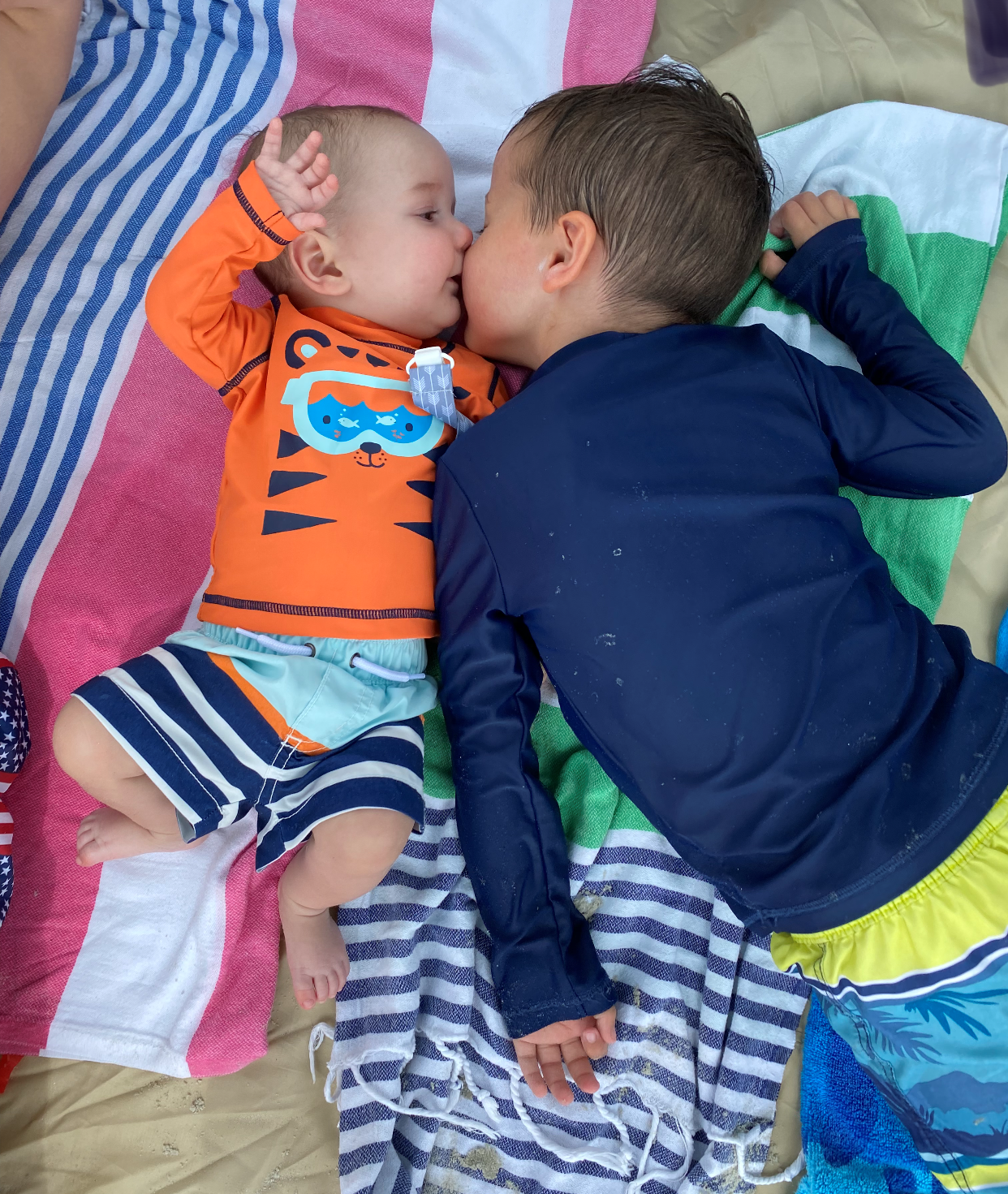 Older brother Griffin gives Henry a kiss at the beach.