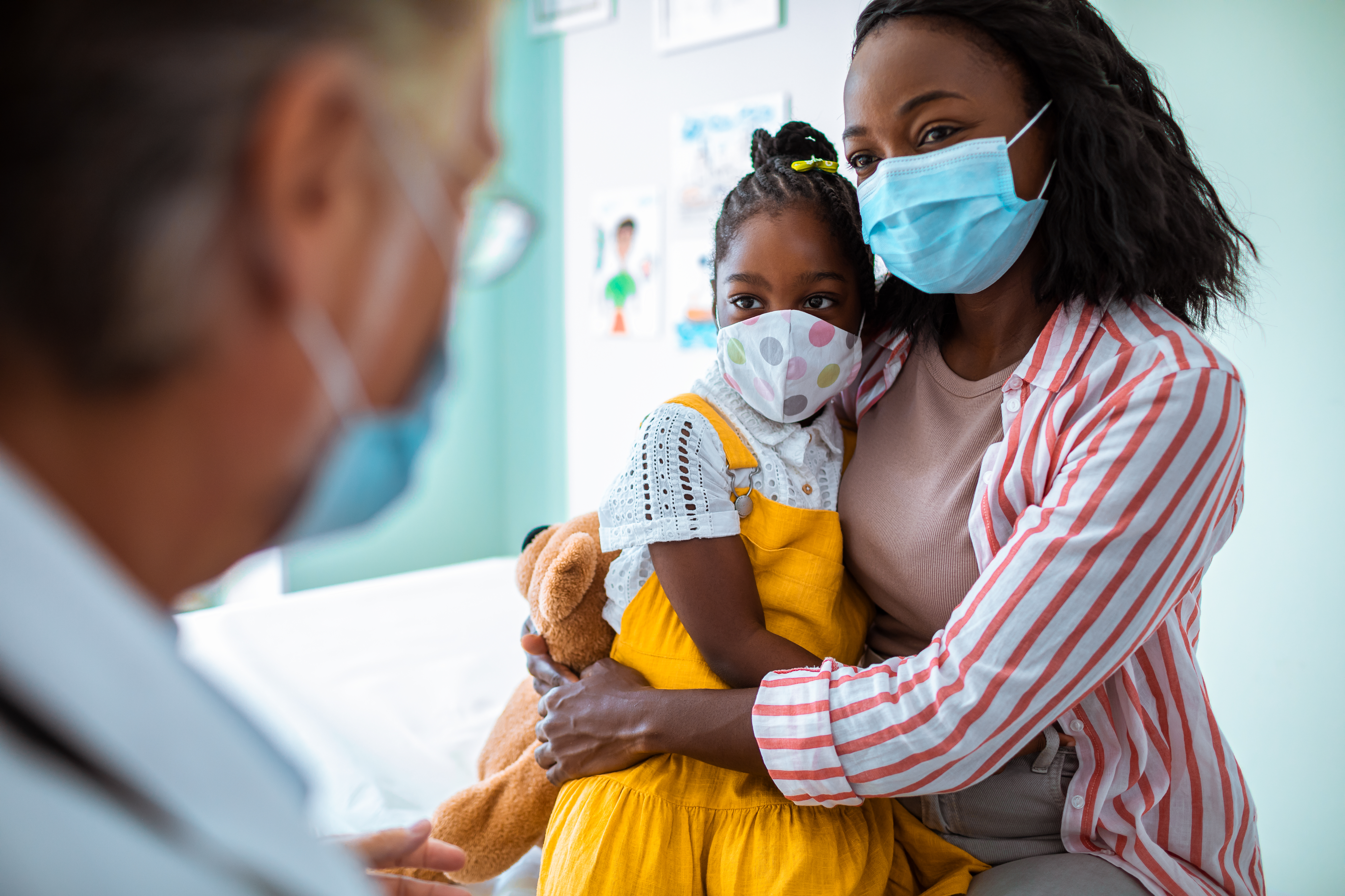 child and mother talking to doctor