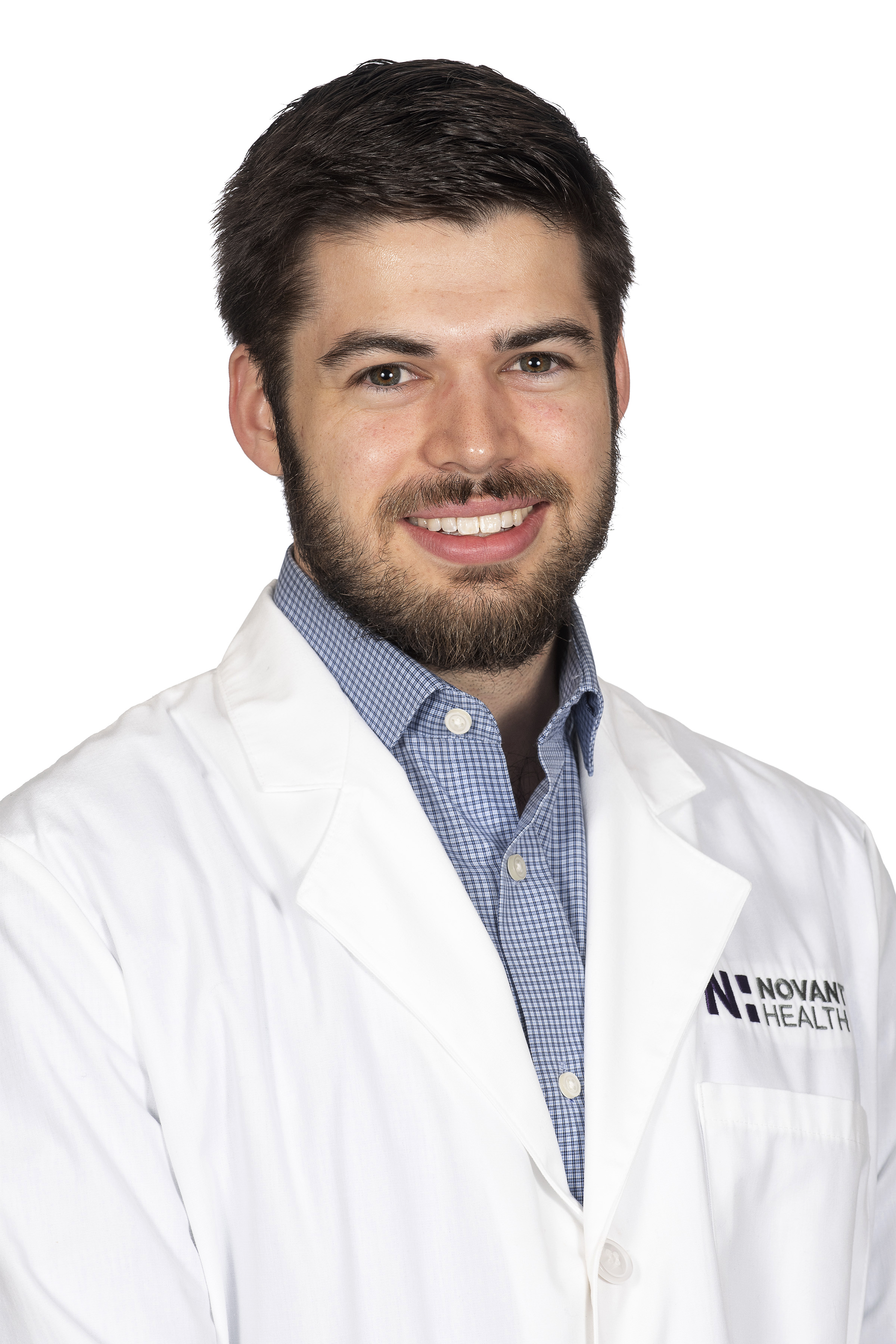 Sean Reynolds, a Novant Health physician assistant, smiles in a white lab coat and blue shirt. 