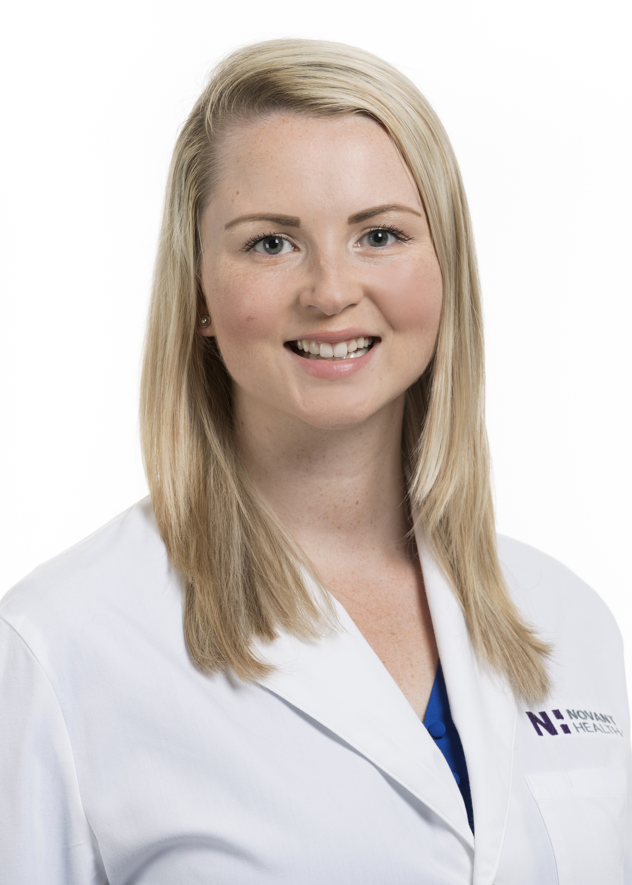 Dr. Lauren Peruski is wearing a white lab coat and is smiling into the camera.