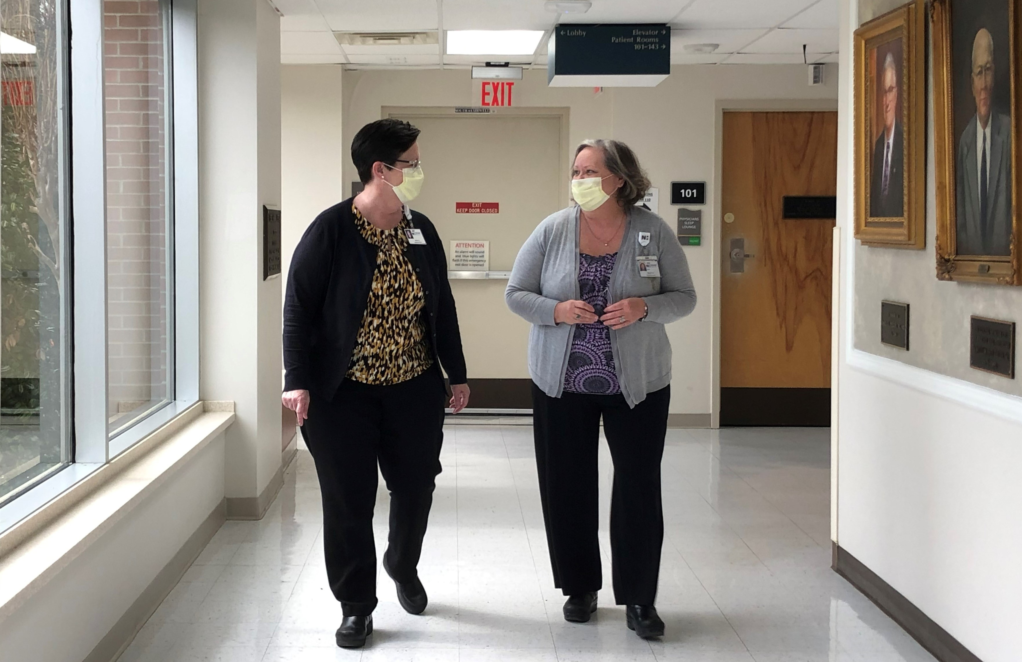 Ruth Glaser and a colleague walk down the hallway of Pender Medical Center together.
