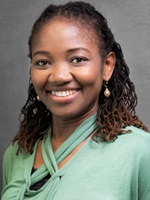Dr. Imelda Odibo wears a green shirt and smiles at the camera.