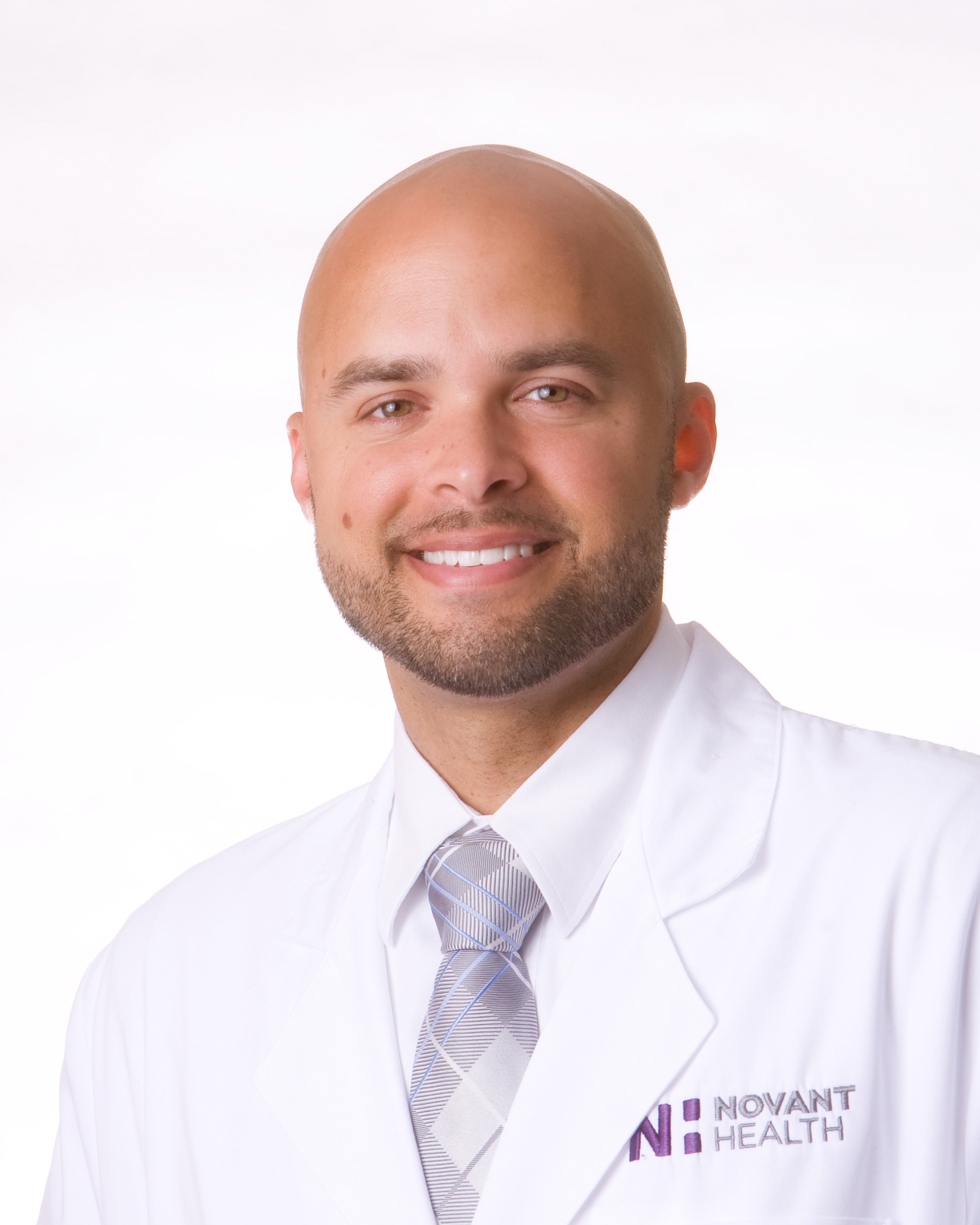 Dr. Augustus Parker is wearing a white lab coat and is smiling into the camera