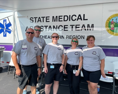 Five EMS team members stand in matching T-shirts and Novant Health name badges.