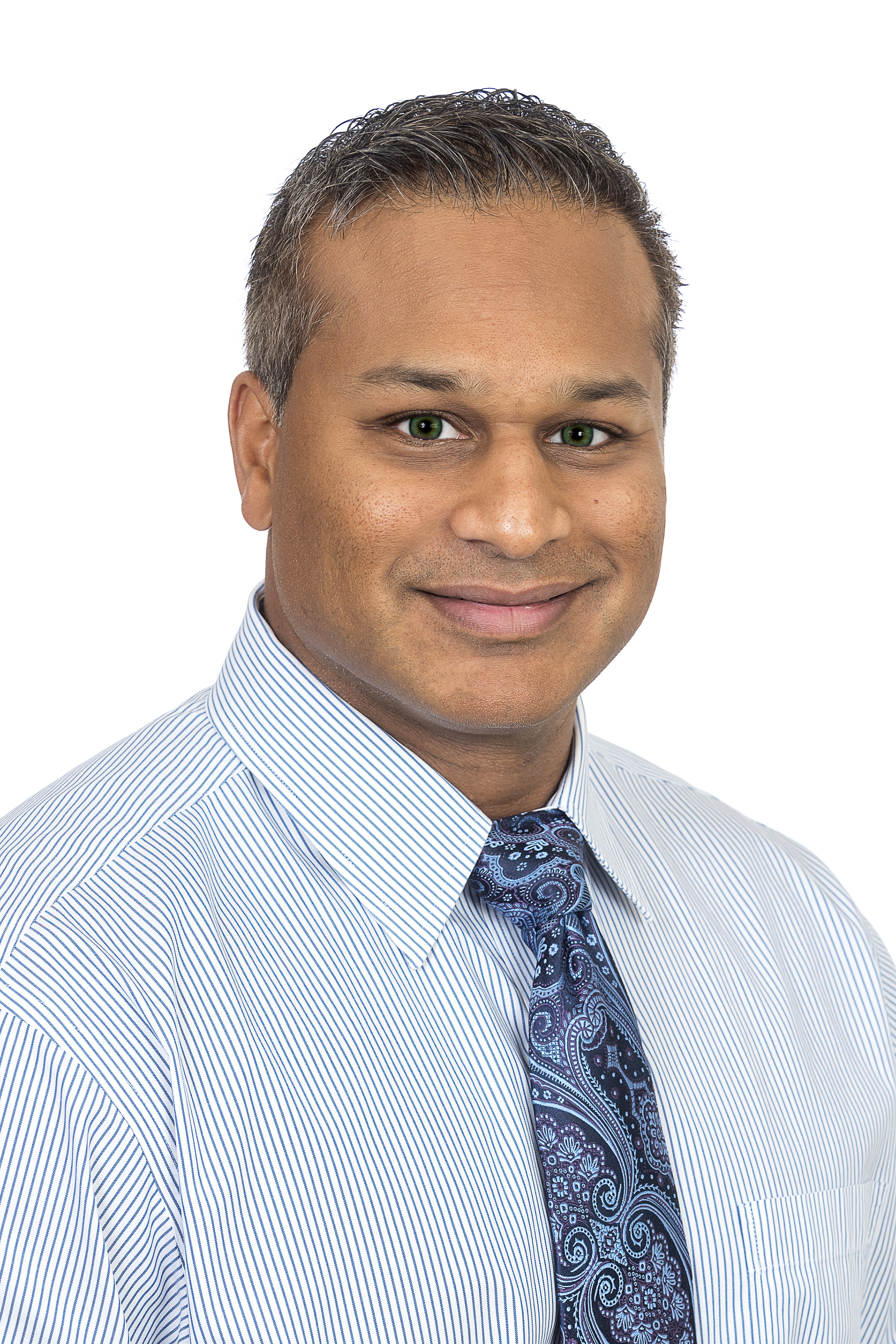 Dr. Nikhil Teppara is wearing a blue dress shirt and is smiling into the camera.