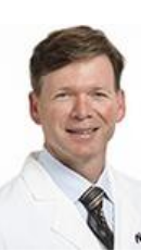 Dr. Steve Martin wears a white coat and smiles.