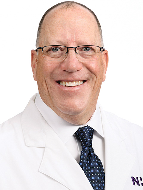 Dr. Cassass wears a white coat and smiles.