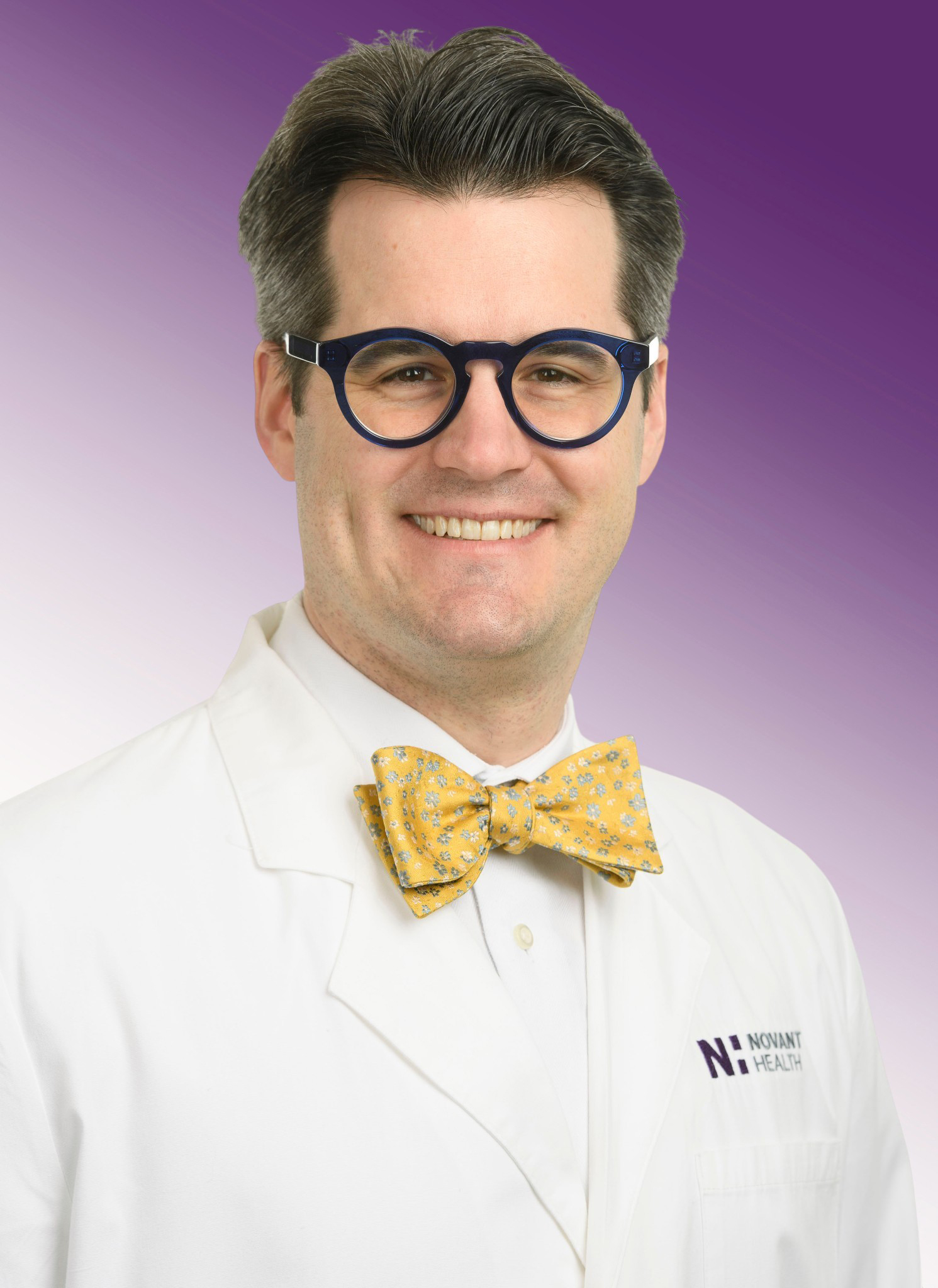 Dr. Ryan Hoffler wears a yellow bowtie and smiles.