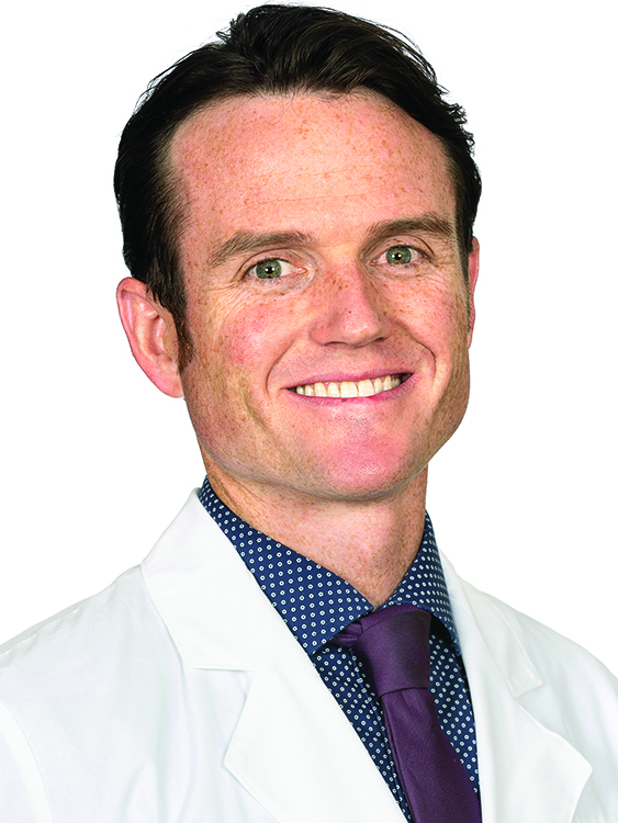 Dr. James Dugan wears a white coat and smiles.