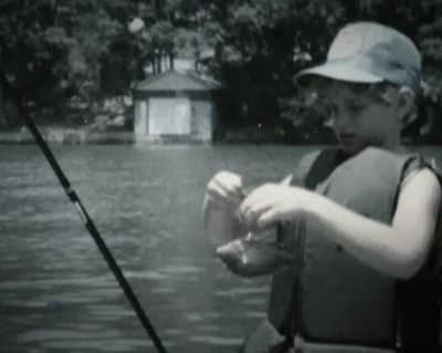A childhood photo of a young Hank Cherry holding a fishing rod.