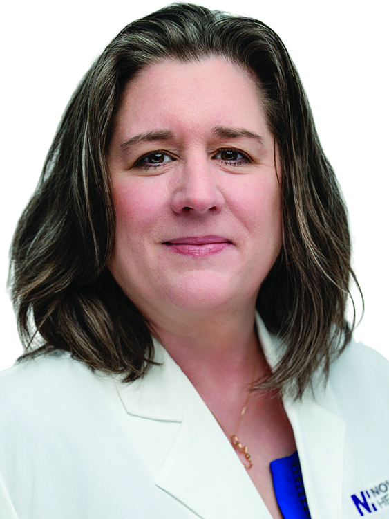 Dr. Karen Henrichsen wears a white coat and smiles.