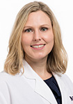 Dr. Erin Kiehna wears a white coat and smiles.