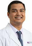 Dr. Sunil Iyer wears a white a coat and smiles.
