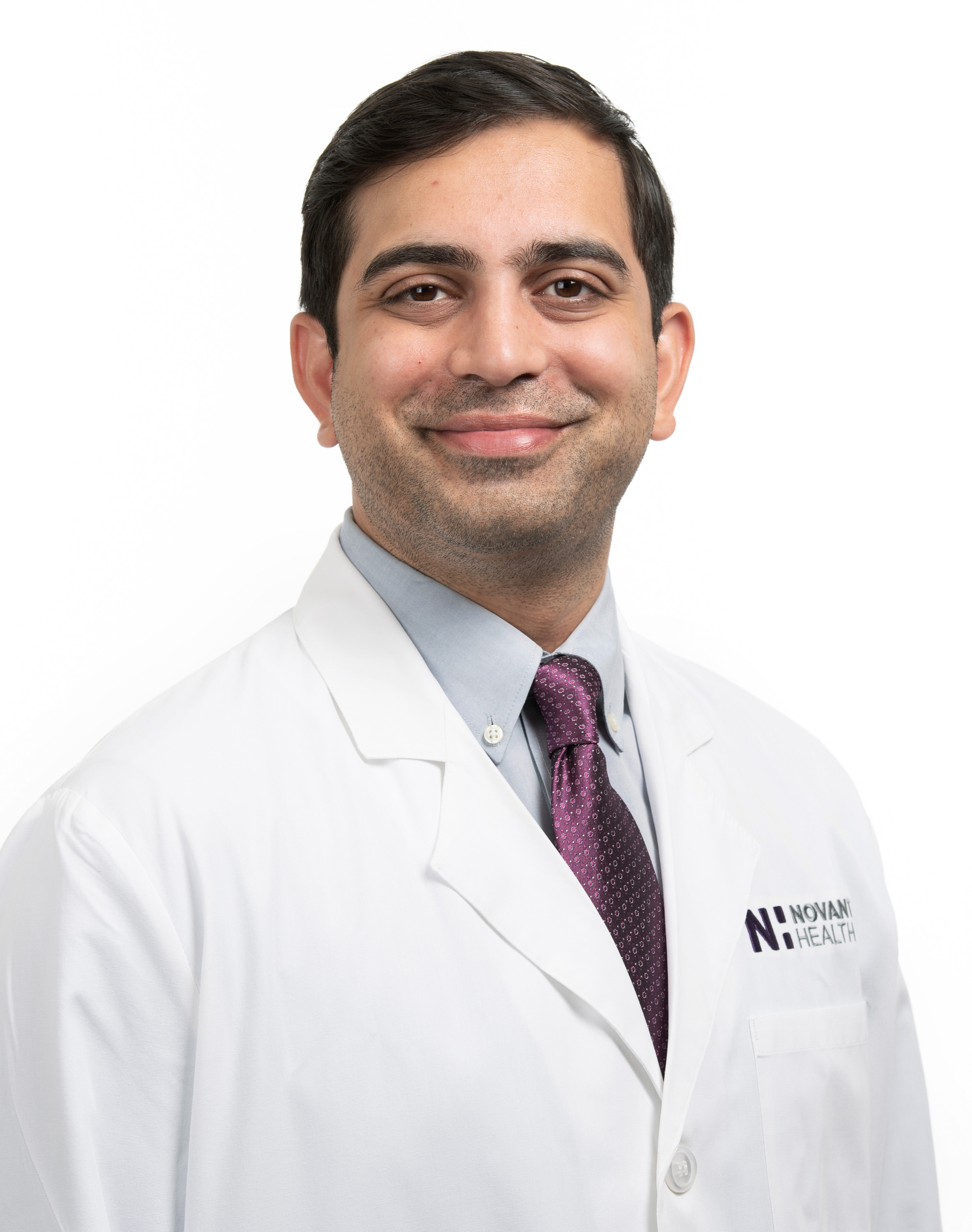 Dr. Dr. Mohammed Shahnawaz wears a white coat and smiles.