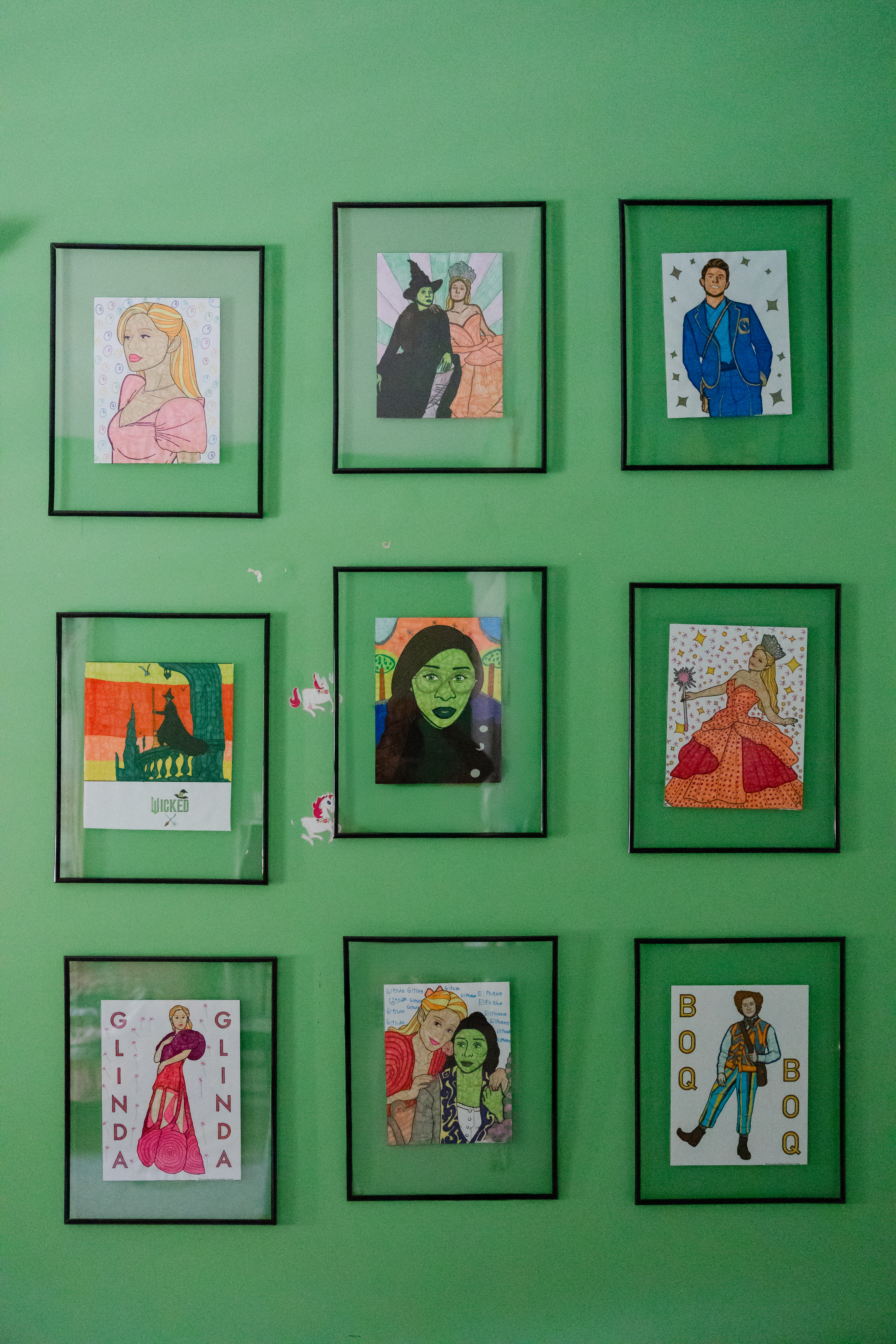 A wall displays framed art Ellie Strickland has drawn.