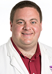 Dr. Brandon Craven wears a white coat and smiles. 