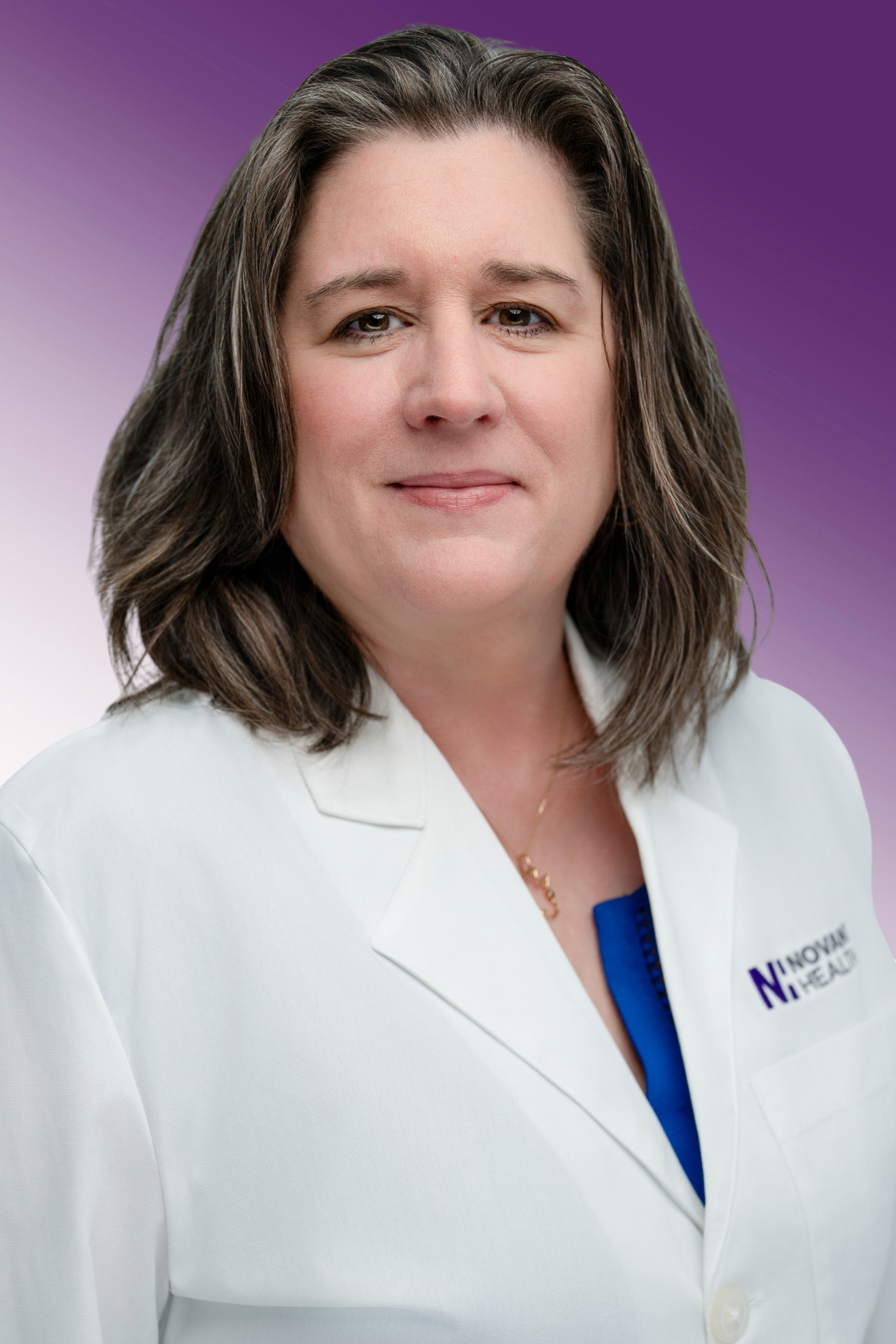 Dr. Karen Henrichsen wears a white coat and smiles.