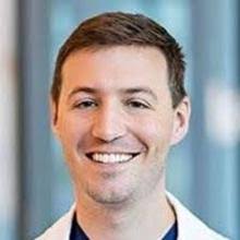 Dr. Greg Davis wears a white coat and smiles.