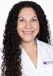 Dr. Maggie Evans wears a white coat and smiles.