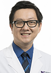 Dr. Daniel Pu wears a white coat and smiles.
