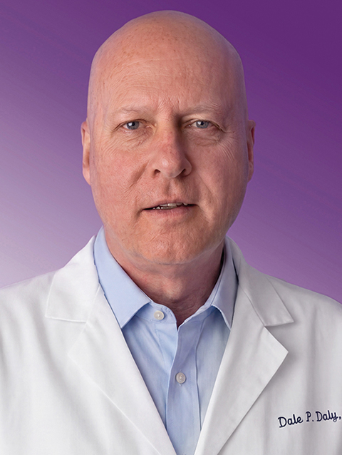 Dr. Dale Daly wears a white coat and smiles.