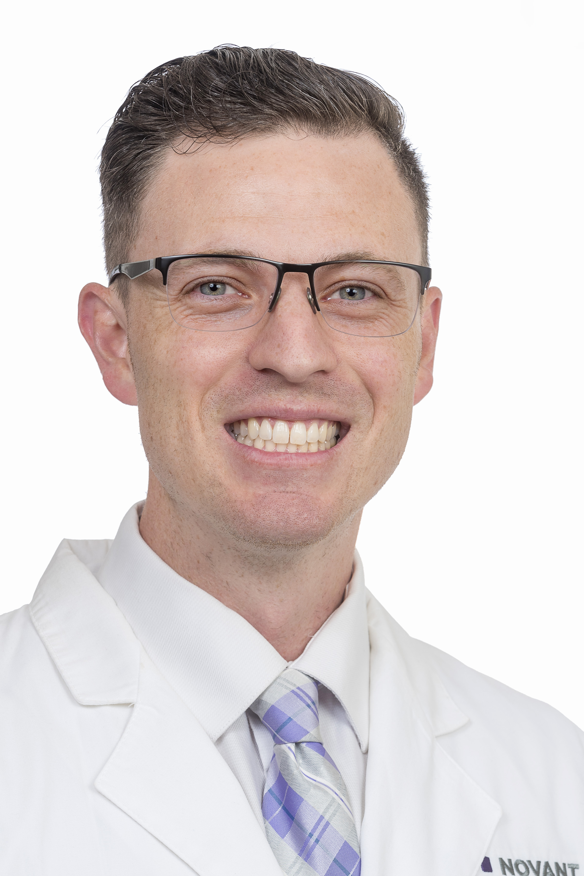 Dr. Devin Simon wears a white coat and smiles.