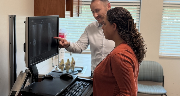Dr. Timothy Ewald and physician assistant Amanda Colon work together, viewing X-ray images on a computer screen.