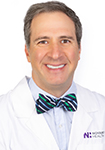 Dr. William Corey wears a white coat and smiles.