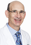 Dr. Michael Drucker wears a white coat and smiles.