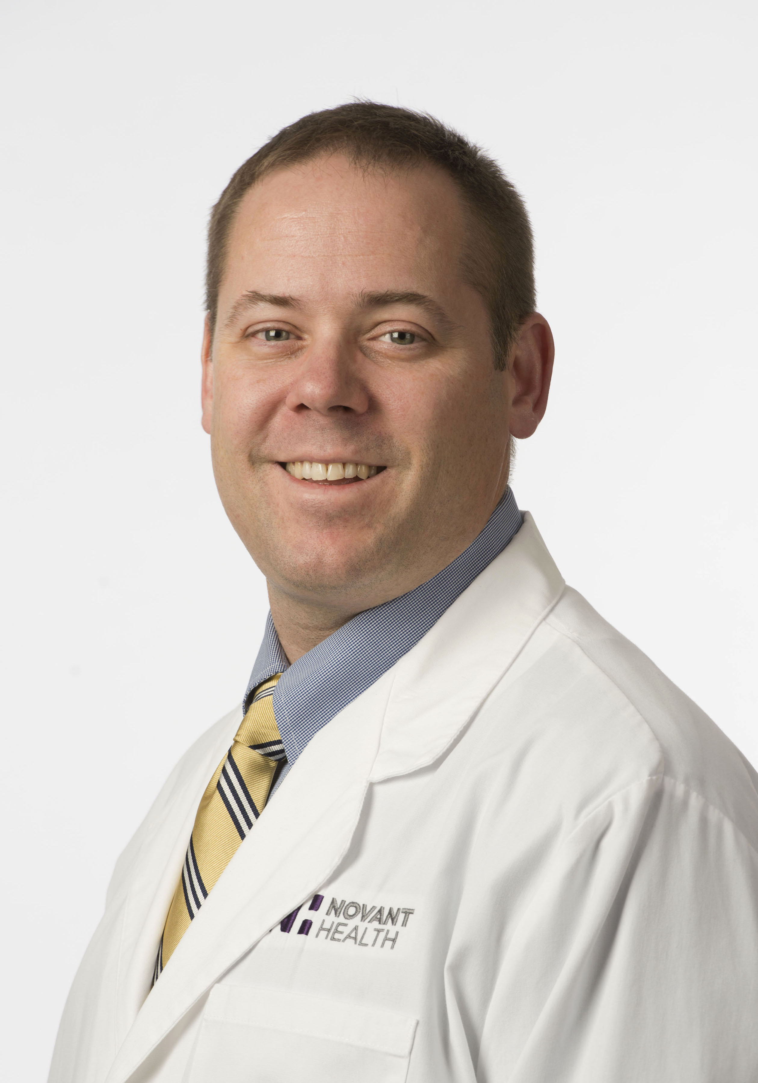 Dr. Jess Kirby wears a white coat and smiles.