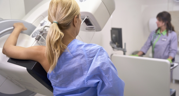 A woman receives a screening mammography in a breast imaging center.
