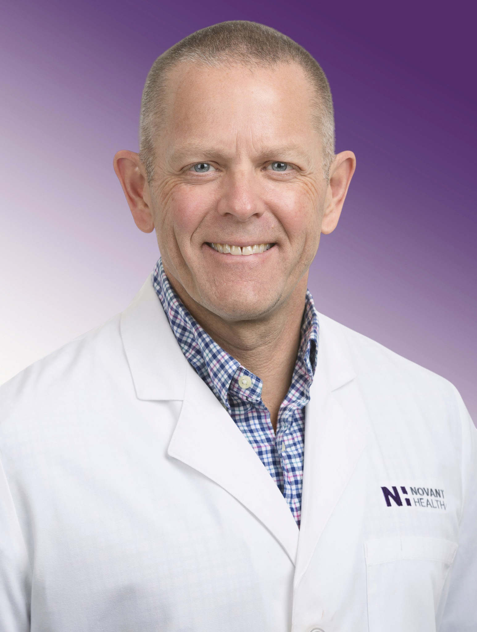 Dr. James Meek wears a white coat and smiles.