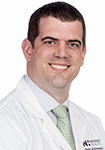 Dr. Scott Nimmons wears a white coat and smiles.
