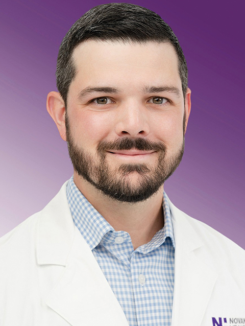 Dr. Kyle McMillen wears a white coat and smiles.