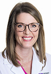 Megan Clarke wears a white coat and smiles.