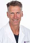 Dr. Estes wears a white coat and smiles. 