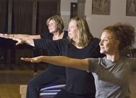 three women doing yoga with arms outstretched