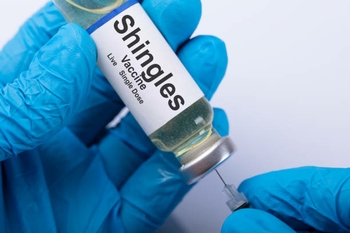 Vial of shingles vaccine in blue-gloved hand