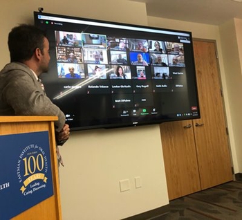 Man looking at screen showing Zoom participants