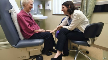 doctors speaks with elderly cancer patient